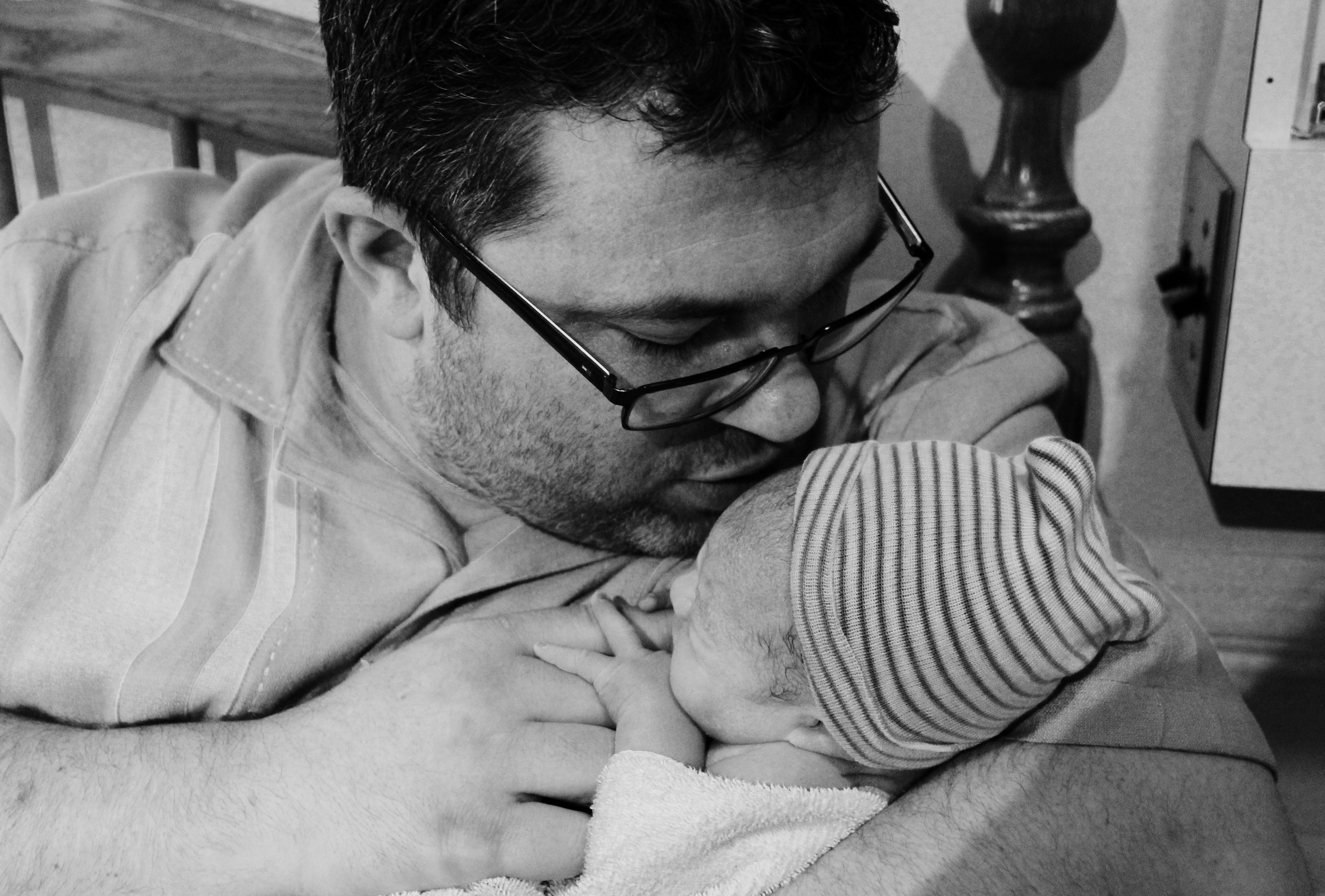 Dad kissing newborn son